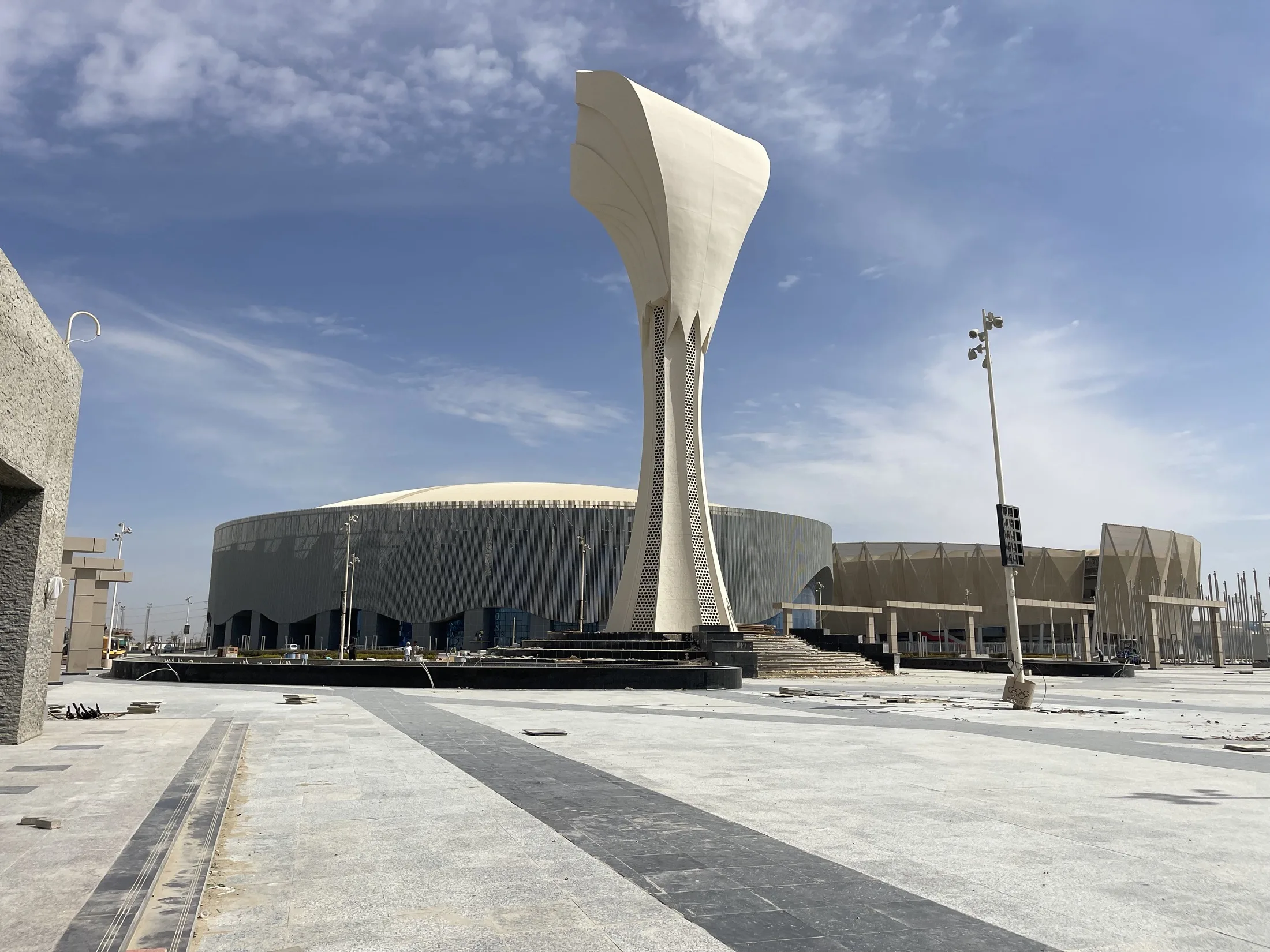 White sculptural Olympic Torch landmark against a blue sky